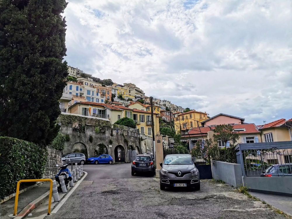 Photographie prise en contrebas de la colline du Piol et ses maisons typiquement niçoises et très colorés